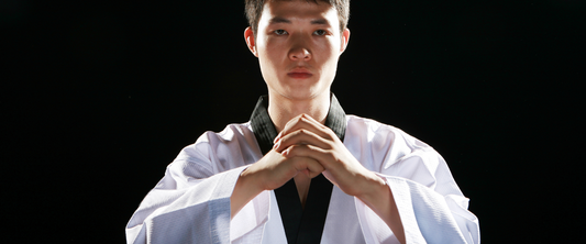 image of taekwondo instructor holding their hands together, they are serious and are in the pre-bowing position